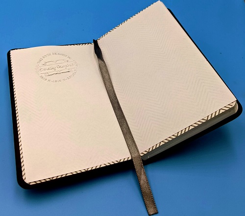 open notebook with left page embossed with a Remarkable Stamp Book Embosser preset design